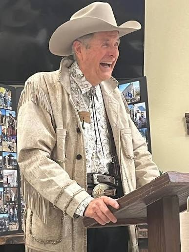 David Murdoch speaking at a podium in western attire